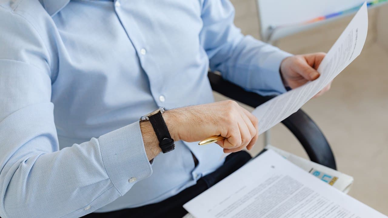 A lender reading through a printed document at a desk
