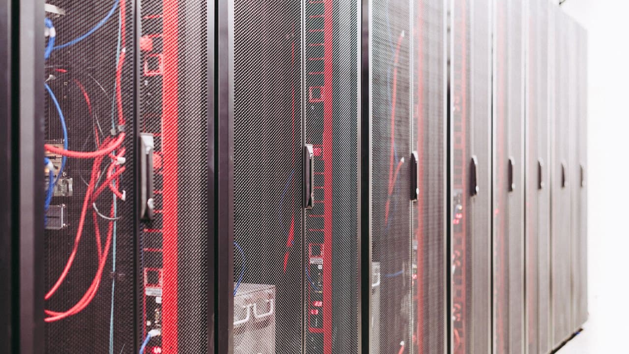 An aisle of server racks with cabling running between them