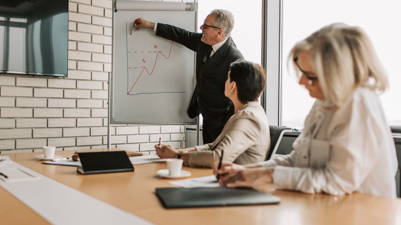 Someone presenting a growth chart on a flip chart to colleagues at a table
