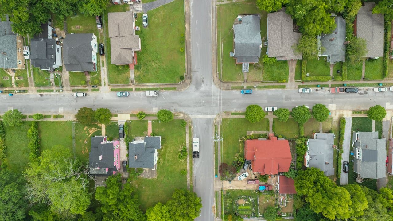 Overhead view of a residential intersection with houses and trees