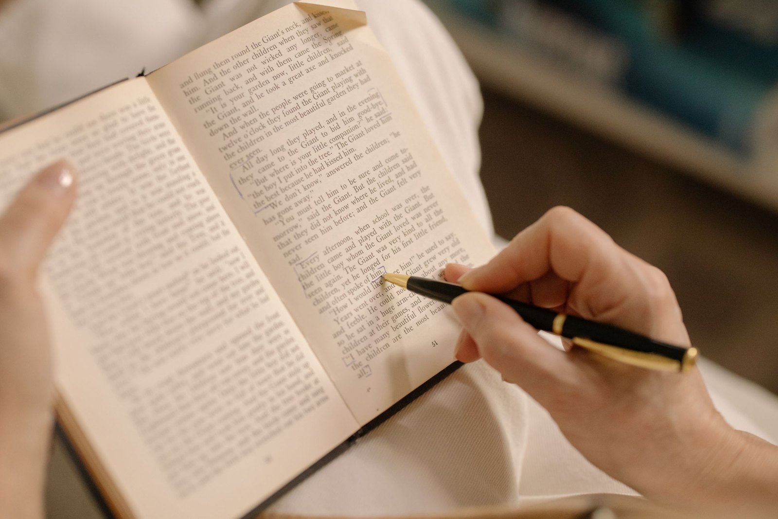Hand marking a line on a printed page with a fountain pen