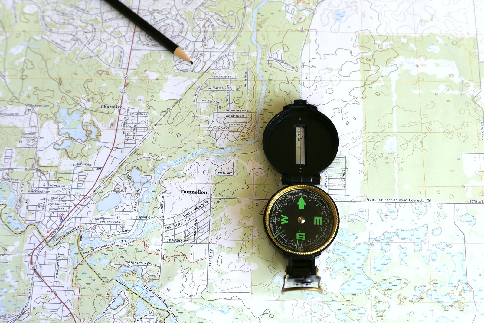 Topographic map of Dunnellon, Florida, with a lensatic compass and a pencil laid across the street grid