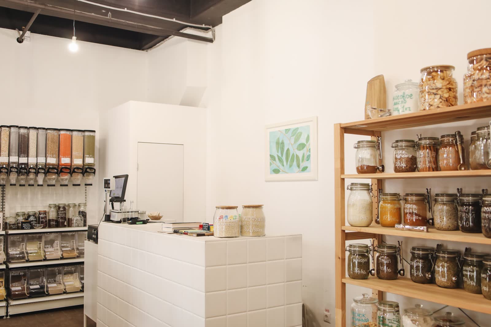 Bright refill shop with a tiled counter and shelves of glass storage jars