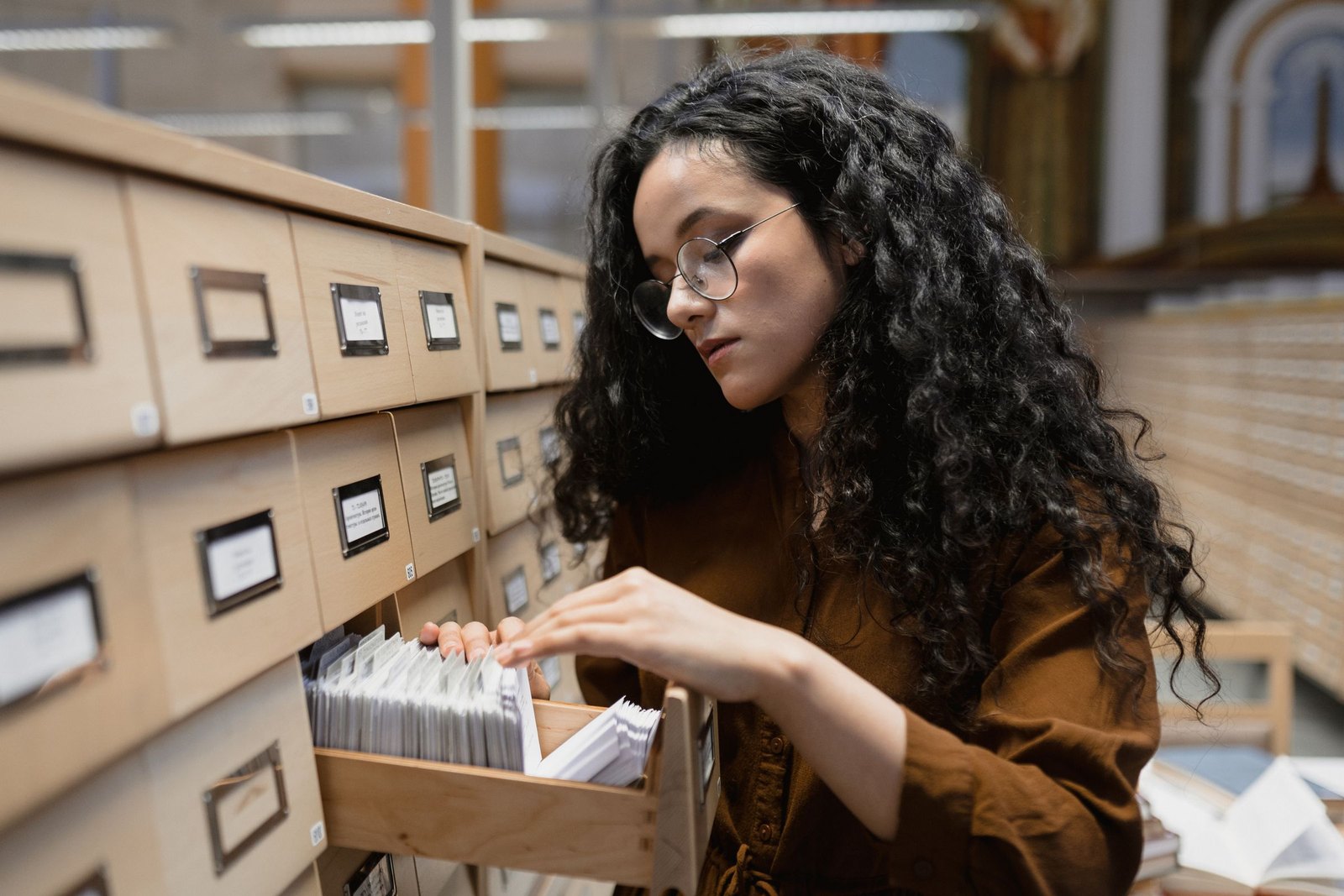 Person searching an open card-catalogue drawer in an archive