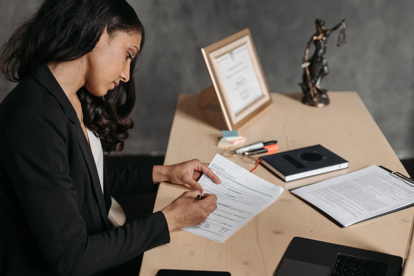 Professional filling out paperwork at an office desk