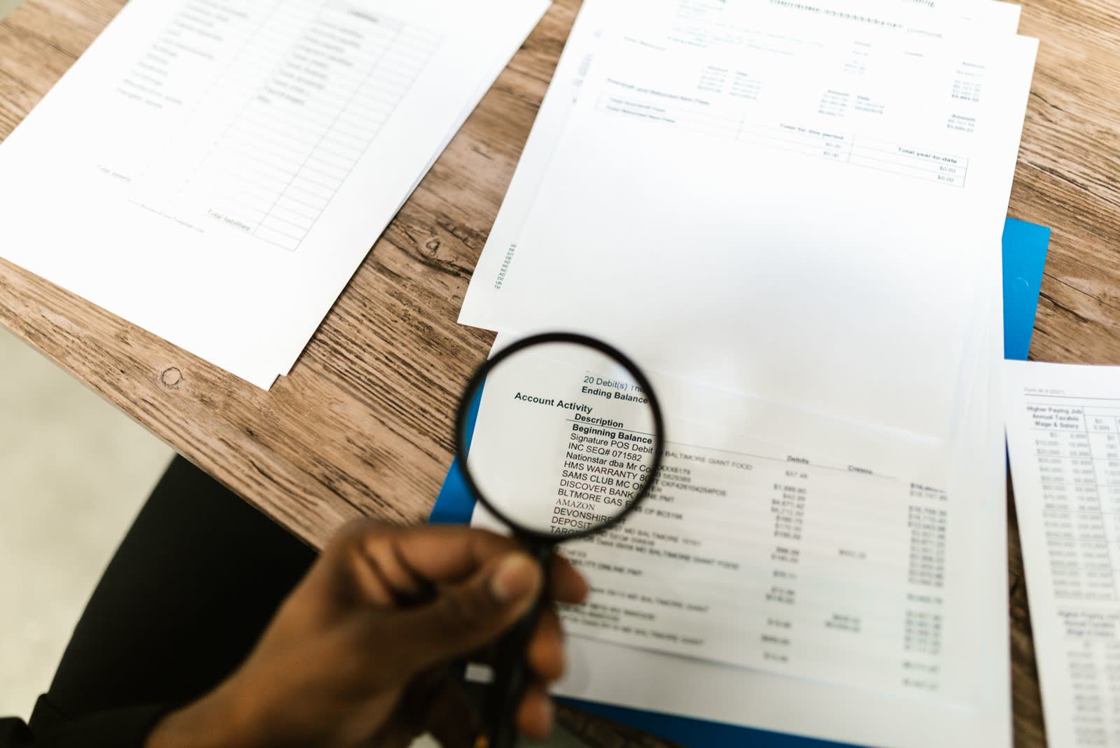 Calculator, pen, and magnifier resting on printed financial charts