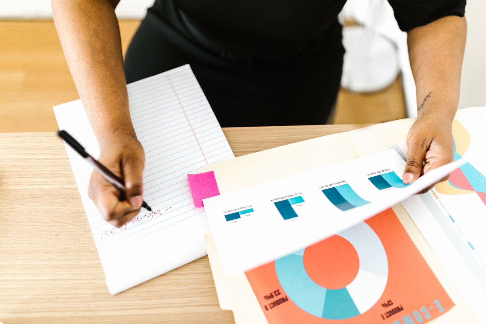 Hands comparing two printed charts across a desk