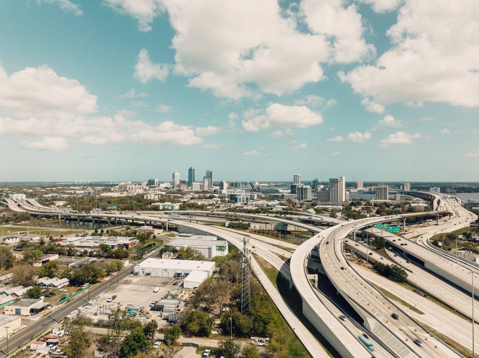 Aerial view of a highway interchange curving toward a city skyline
